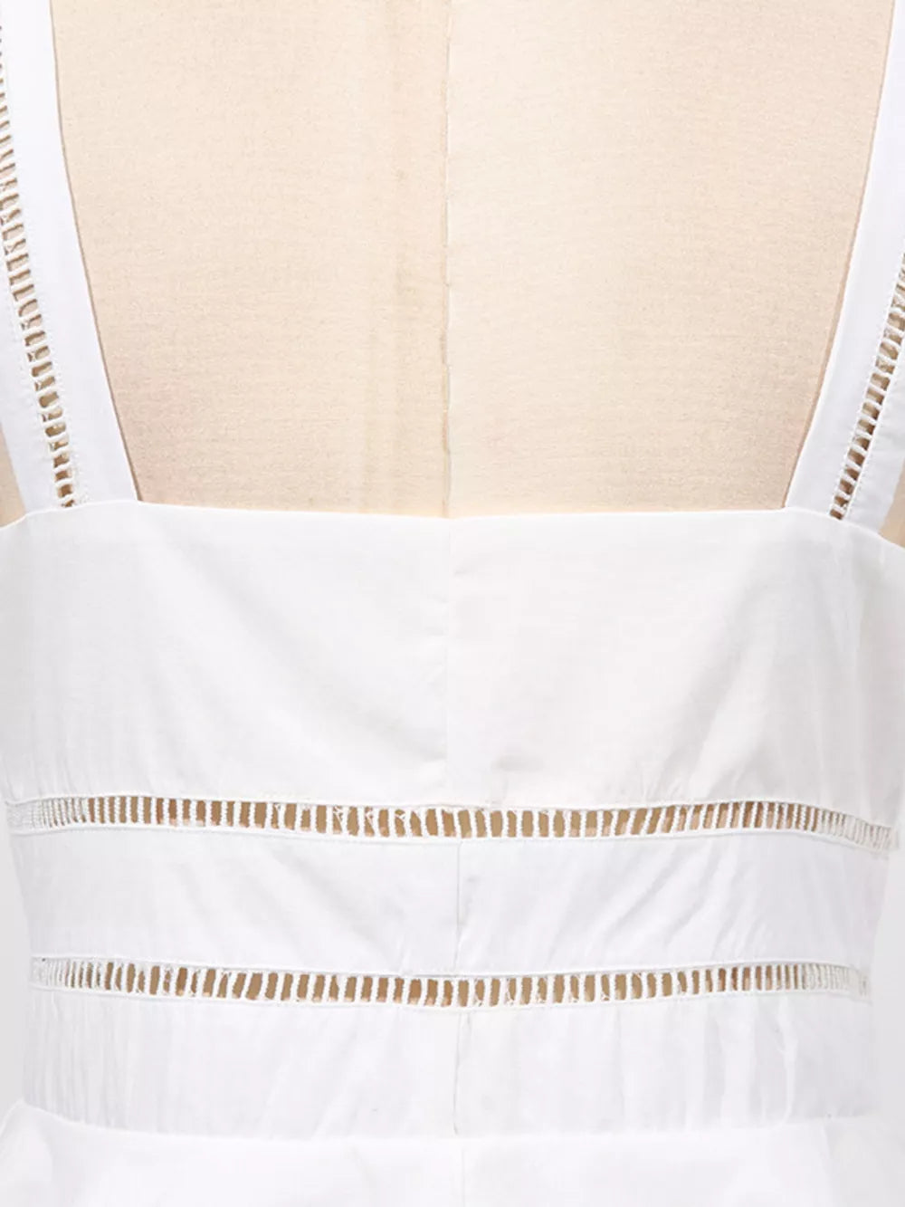White midi dress with eyelet embroidery detail on straps and horizontal cutouts.