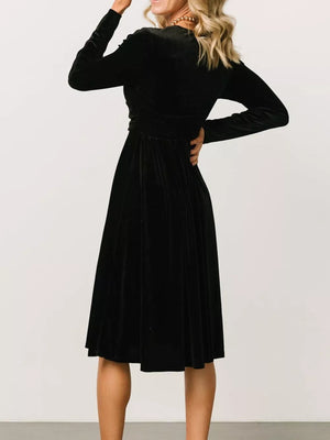 Black velvet midi dress with long sleeves and a-line skirt.
