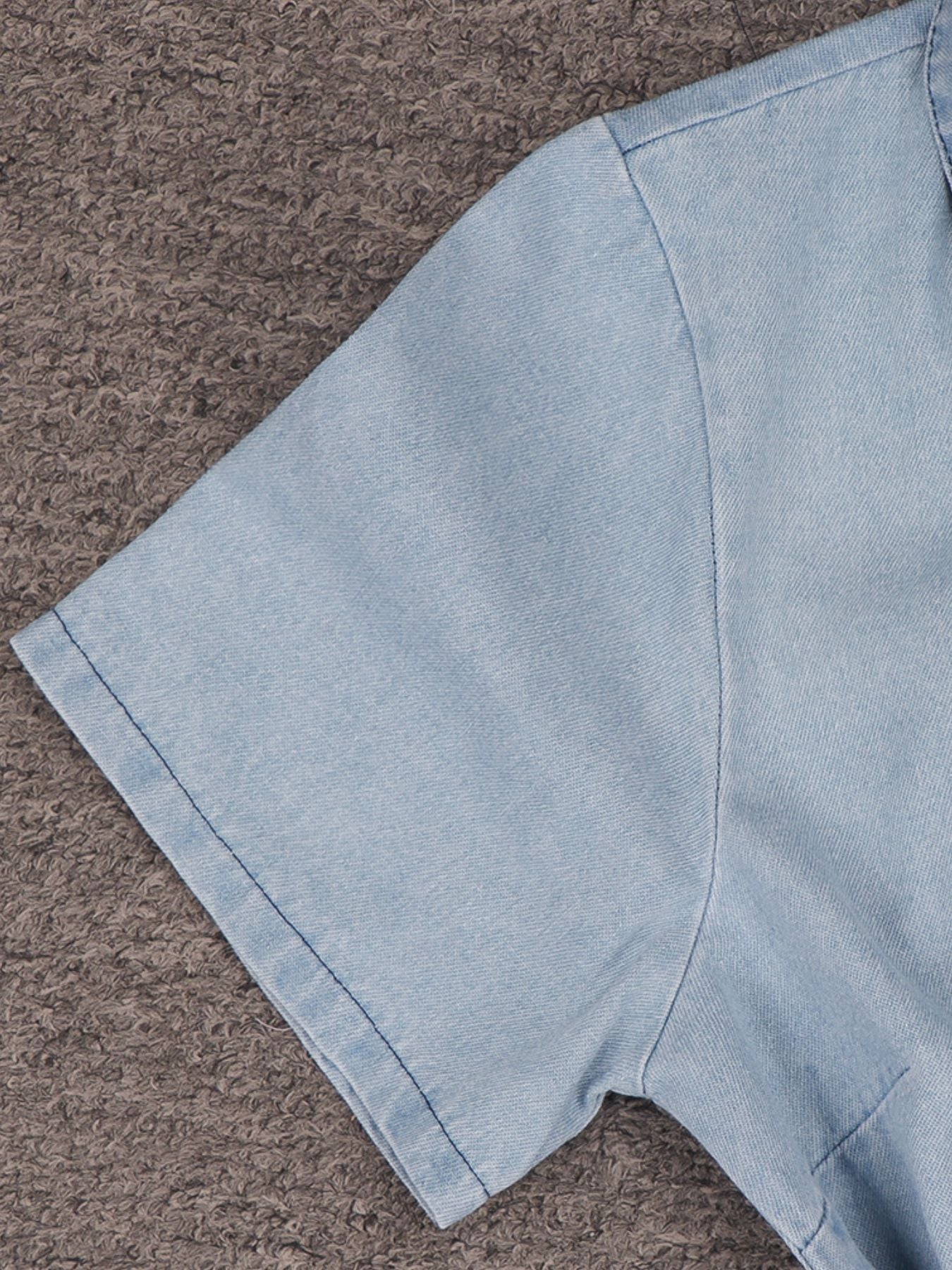 Light wash denim mini dress with short sleeves and a collared neckline.
