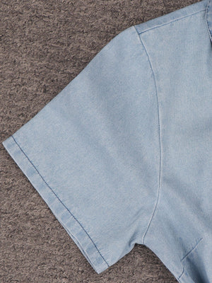 Light wash denim mini dress with short sleeves and a collared neckline.