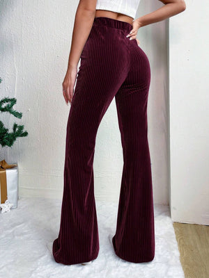 Burgundy corduroy bell bottom trousers with vertical ribbing.