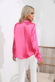 Hot pink glossy satin button-down blouse with long sleeves.