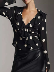 Black polka dot sheer blouse with V-neck and ruffled details.