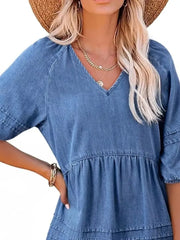 Denim mini dress with V-neck, puff sleeves, and tiered skirt in blue.