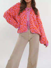 Vibrant leopard print tie-front cardigan in pink and orange with balloon sleeves.