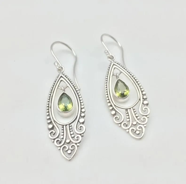 Silver filigree drop earrings with pear-shaped peridot stones.
