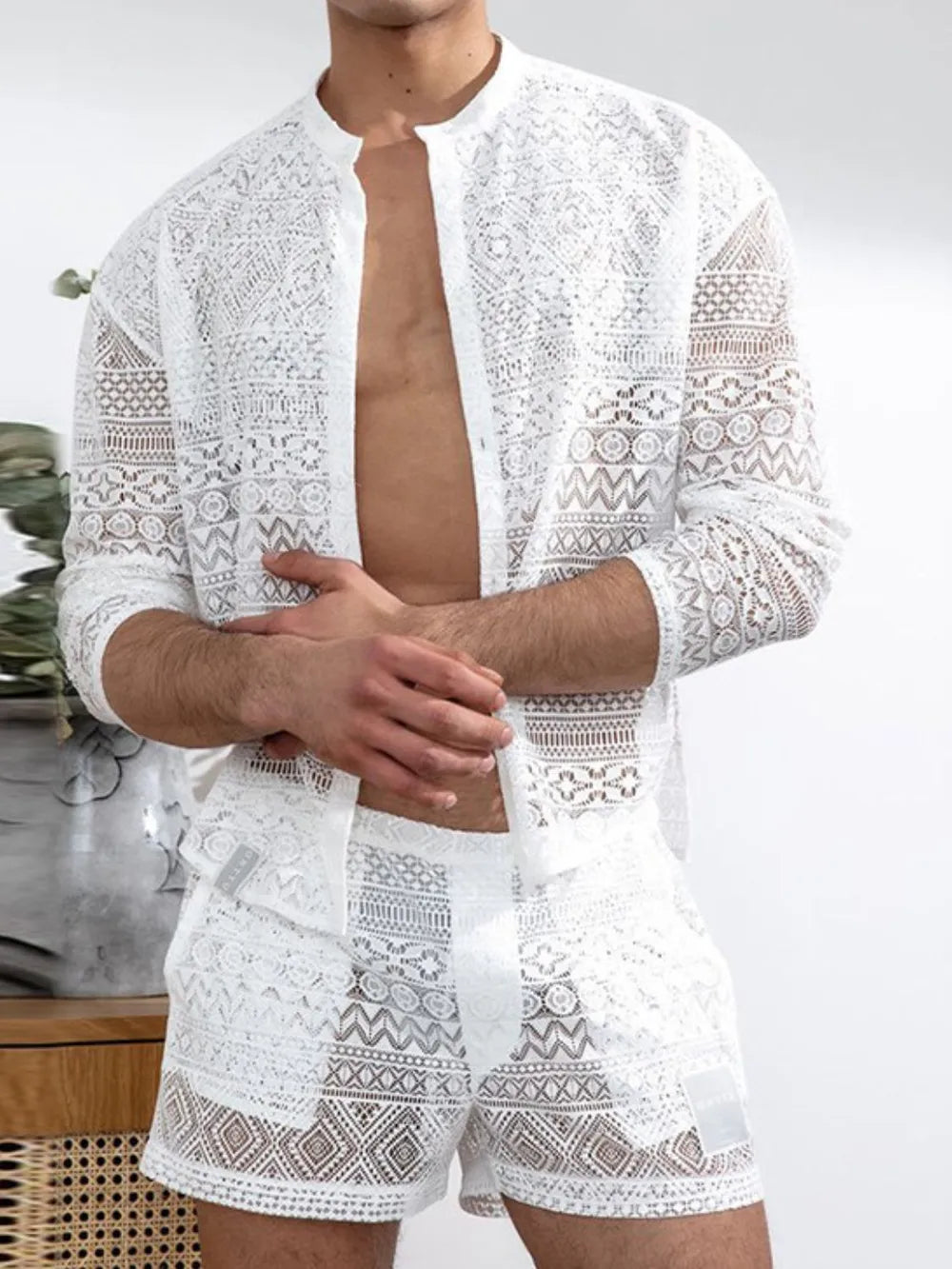 White open-weave crochet resort set with intricate patterns, featuring a button-up shirt and shorts.