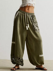 Moss harem pants with drawstring, lace trim, and floral embroidery detail.