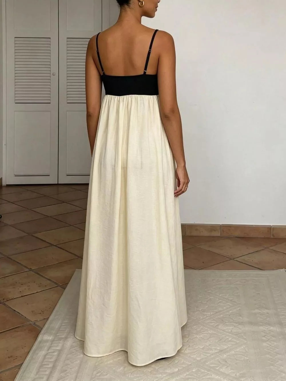 Elegant two-tone maxi dress with spaghetti straps, black bodice, cream skirt.