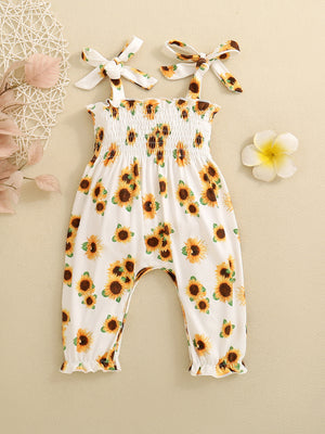 Baby white cotton jumpsuit with allover sunflower print, smocked bodice and tie straps.