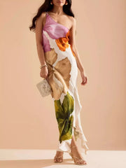 Floral one-shoulder maxi dress with cascading ruffle and large bloom print in pink, orange, and green.