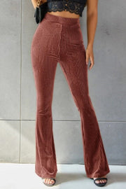 Ribbed velvet palazzo trousers in rust, with a high waist and flared leg.