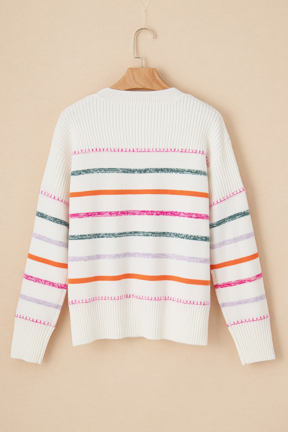 White ribbed knit pullover sweater with colorful horizontal stripes and crew neck.