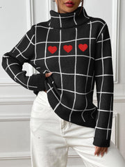 Black turtleneck sweater with white grid pattern and three red heart appliqués.