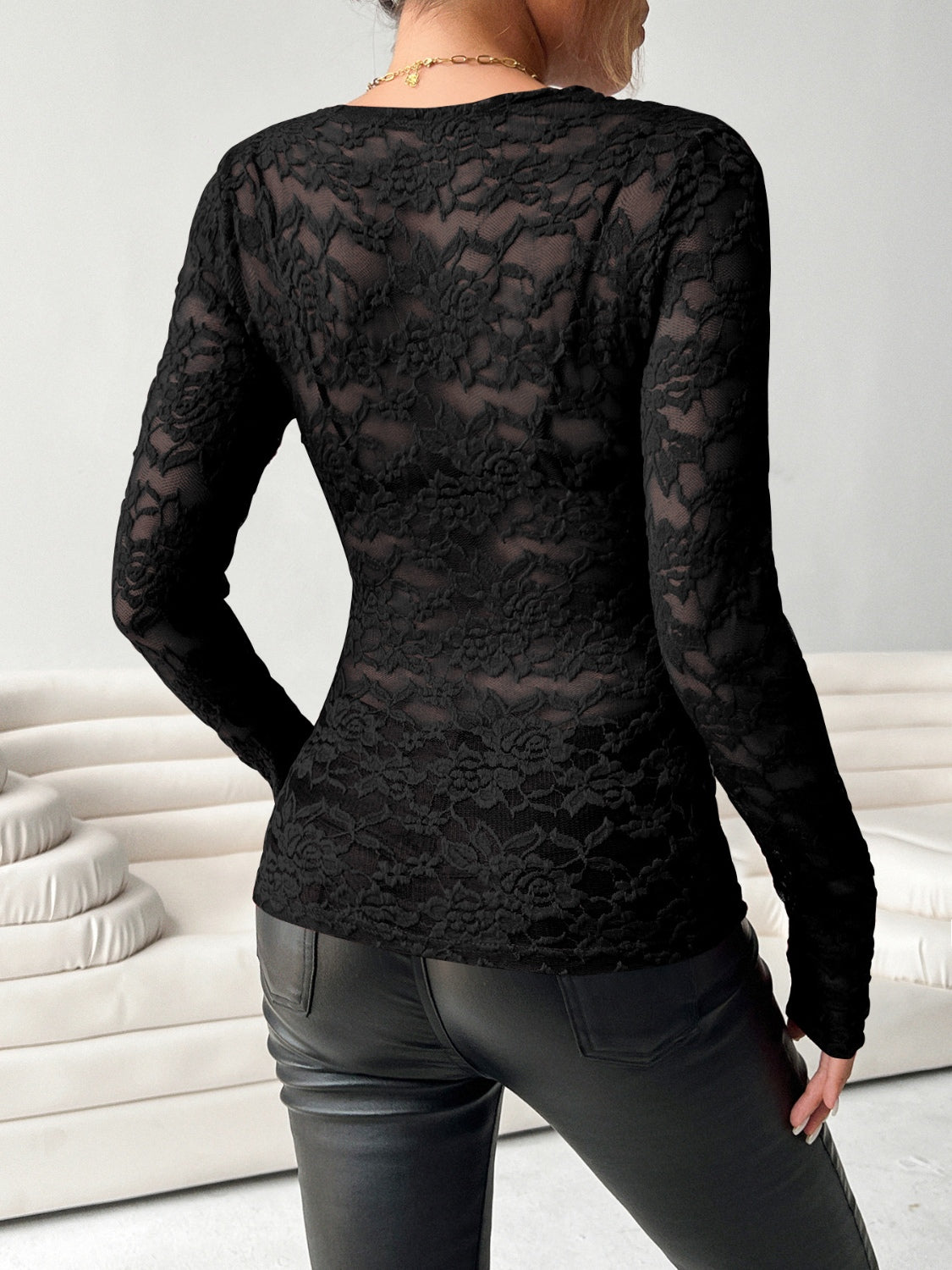 Black lace second-skin top with long sleeves and floral pattern.