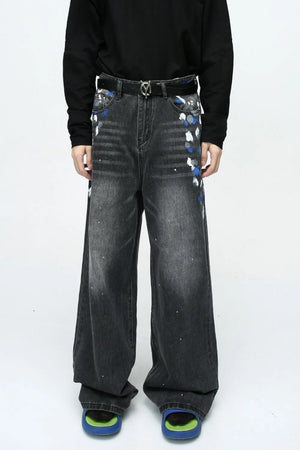 Dark wash wide leg jeans with artistic brushstroke paint splatters and a distressed finish.