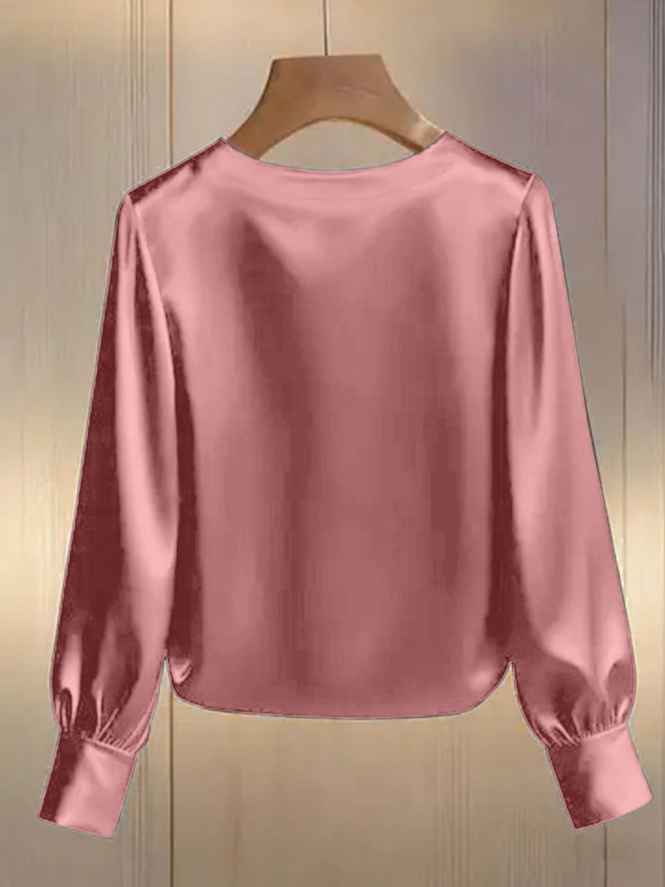 Pink satin blouse with round neck, long sleeves, and pearl trim detail.