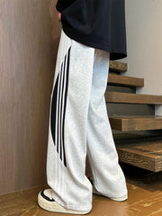 Men's light gray wide leg casual trousers with black and white side stripe detail.