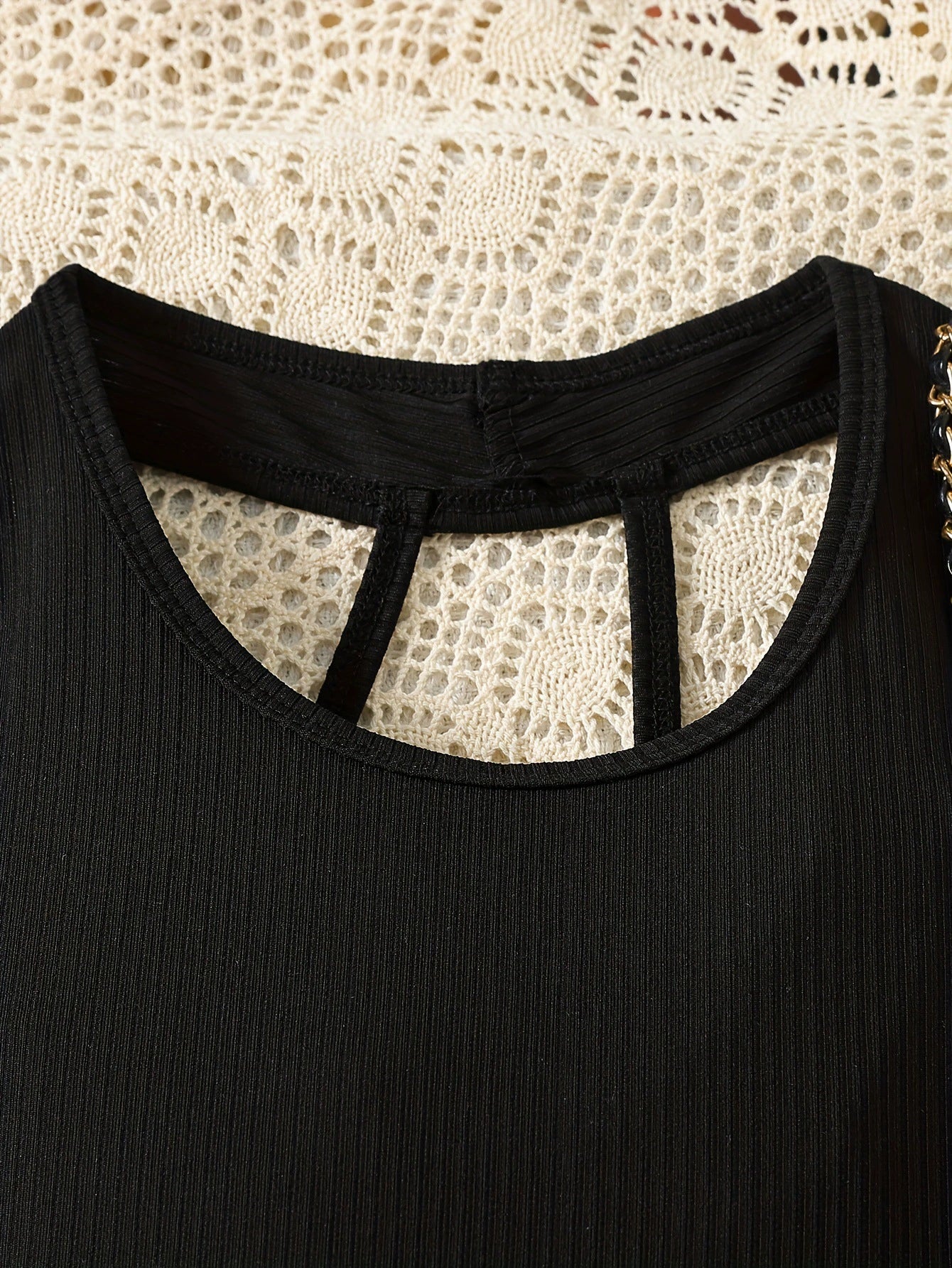 Black ribbed baby outfit with cutout neckline detail and chain strap accent
