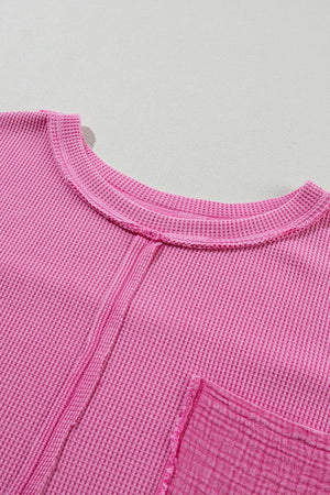 Fuchsia pink waffle knit top with raw seam detail and pocket.