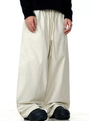 Relaxed wide-leg trousers in light beige with a drawstring waist and casual fit.