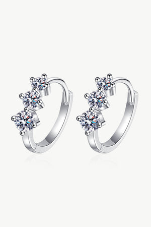 Silver huggie earrings with three clear cubic zirconia stones in a cluster design