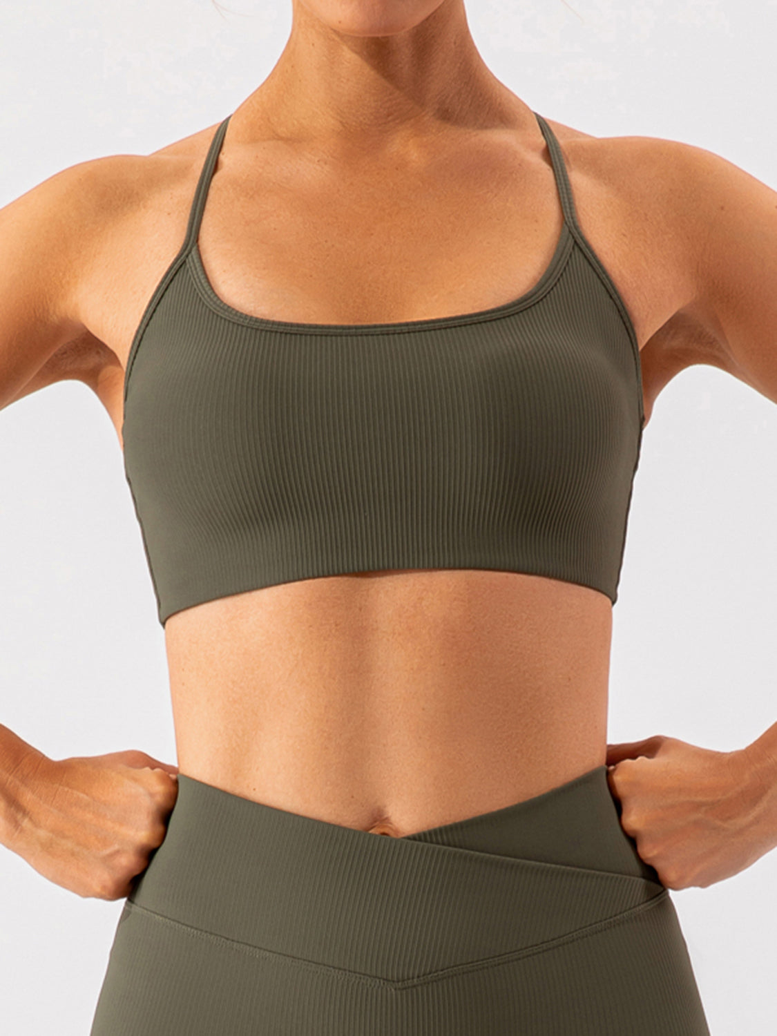 Ribbed halterneck active bra in matcha green with thin straps and a scoop neckline.