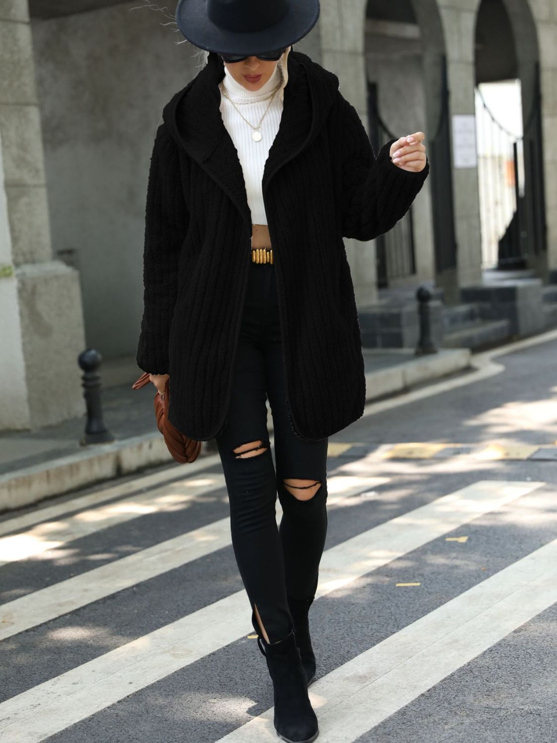 Black textured teddy hooded open coat with a relaxed fit, styled with ripped black jeans.