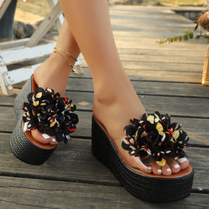 Floral pom-pom wedge sandals in multicolor with clear straps and braided platform.