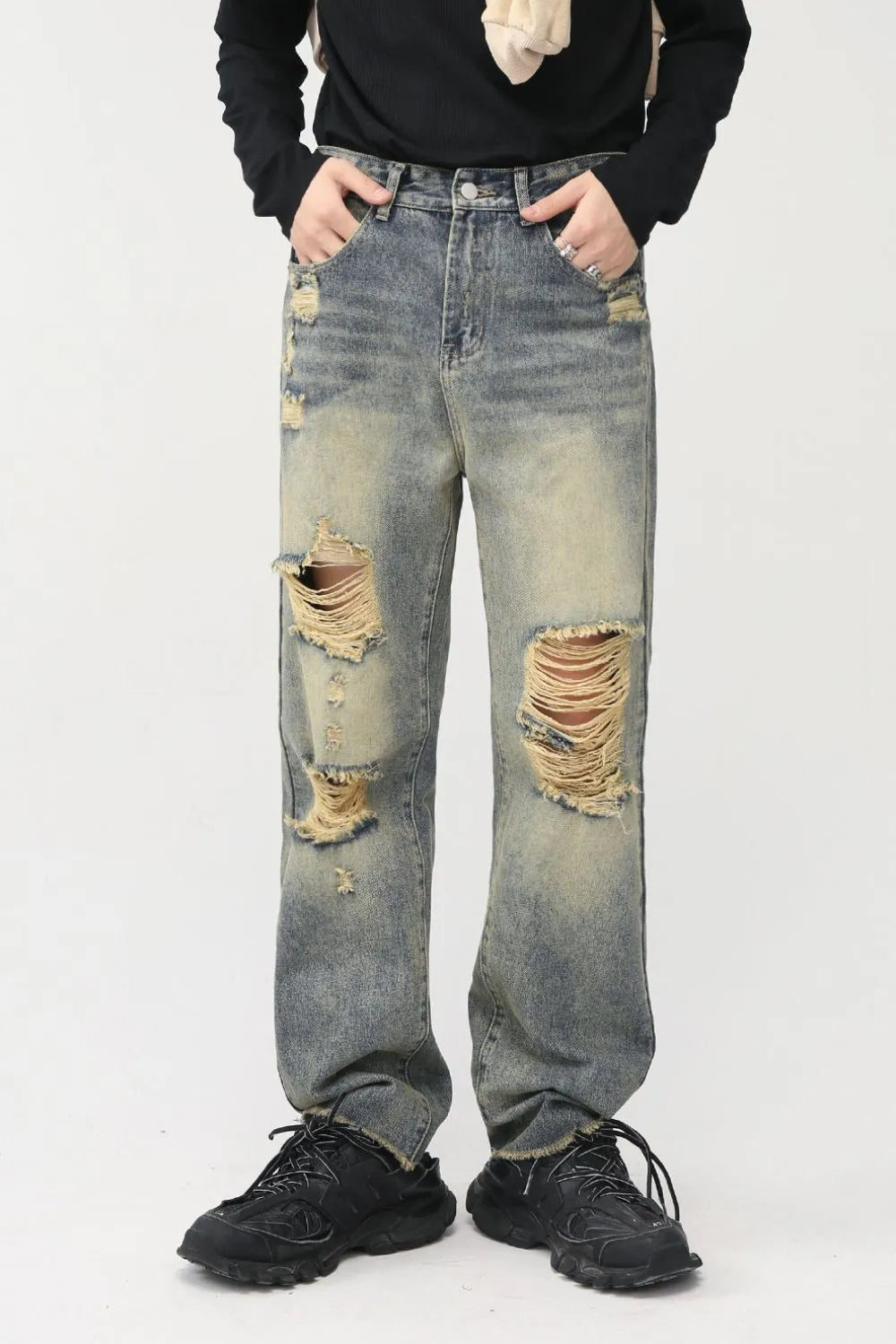 Distressed baggy denim jeans in medium wash with shredded knees and frayed hems.