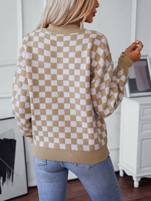 Checkerboard knit pullover sweater in camel and white with a mock neck.