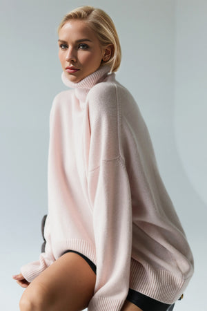 Oversized pink cashmere turtleneck sweater with relaxed fit and ribbed cuffs.