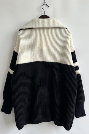 Ribbed knit quarter-zip sweater in black and white with striped sleeves.