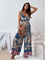 Paisley patterned wide-leg romper in blue with a tied belt and fringe bag.