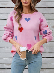 Pink acrylic knit sweater with bubble sleeves and a scattered heart motif.