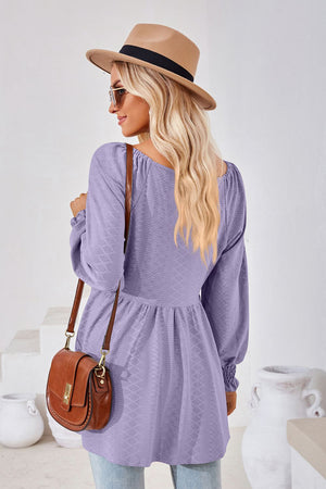 Lavender textured babydoll blouse with smocked cuffs and square neckline.