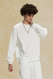 White oversized crewneck sweatshirt with subtle shoulders and long sleeves.
