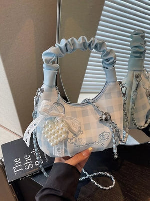 Charming mini crossbody bag in light blue gingham with ruched handle and pearl heart charm.