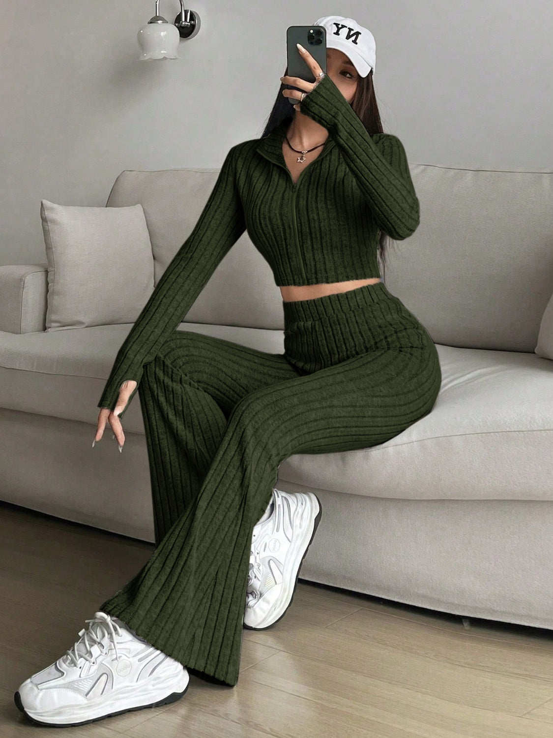 Ribbed knit crop zip-up top and flare pants set in army green, styled casually.