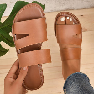 Chic open toe flat sandals in dark brown with double strap detail.