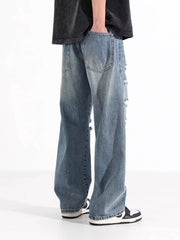 Men's washed blue distressed wide-leg jeans with ripped details.
