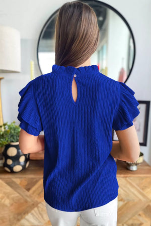 Blue textured short sleeve shirt with ruffle trim and keyhole back detail.