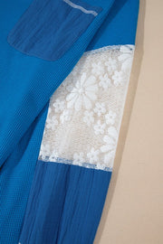 Blue waffle knit top with white lace panel and blue fabric detail.