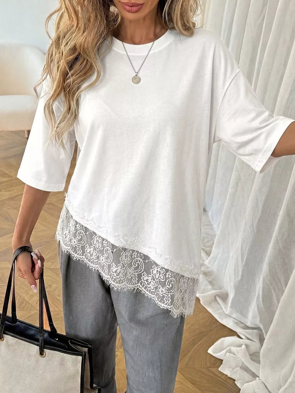 White half-sleeve tee with asymmetrical lace trim detail.