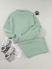 Sage cotton zip-up jacket and drawstring pants set with collared neckline and elastic cuffs.