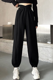 Black pleated waistline joggers with a crisscross detail and elastic cuffs.