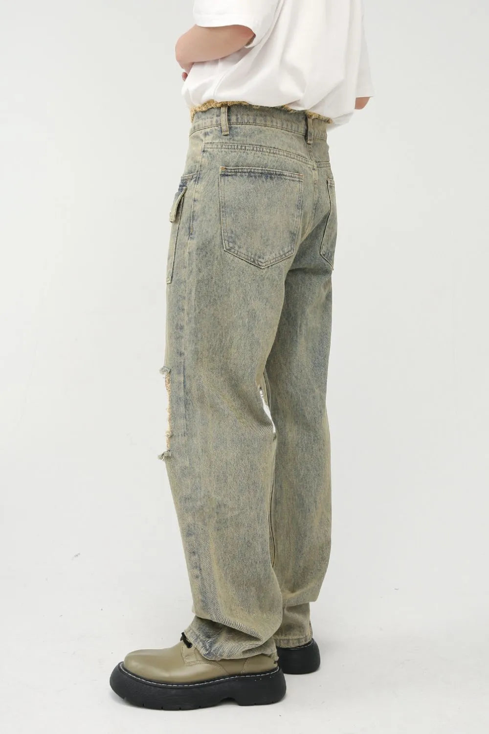 Distressed cargo jeans in medium wash denim with cut-out details and frayed hem.