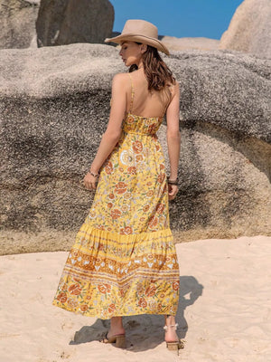 Yellow floral print cami maxi dress with tiered skirt and tassels.
