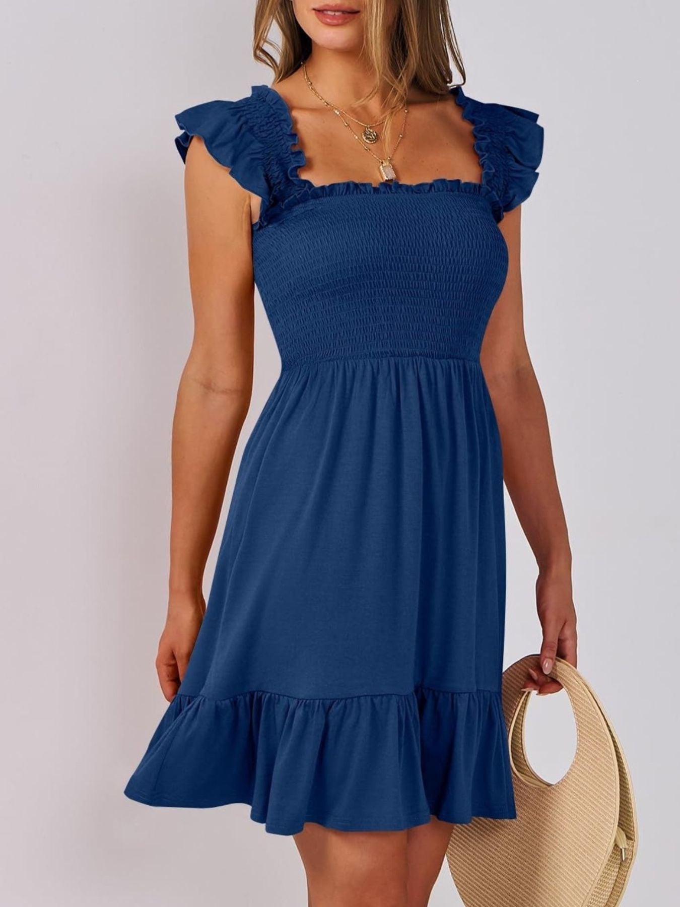 Navy smocked ruffle hem mini dress with square neckline and flutter sleeves.