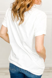 White t-shirt with rolled sleeves and a watercolor graphic detail on the front.